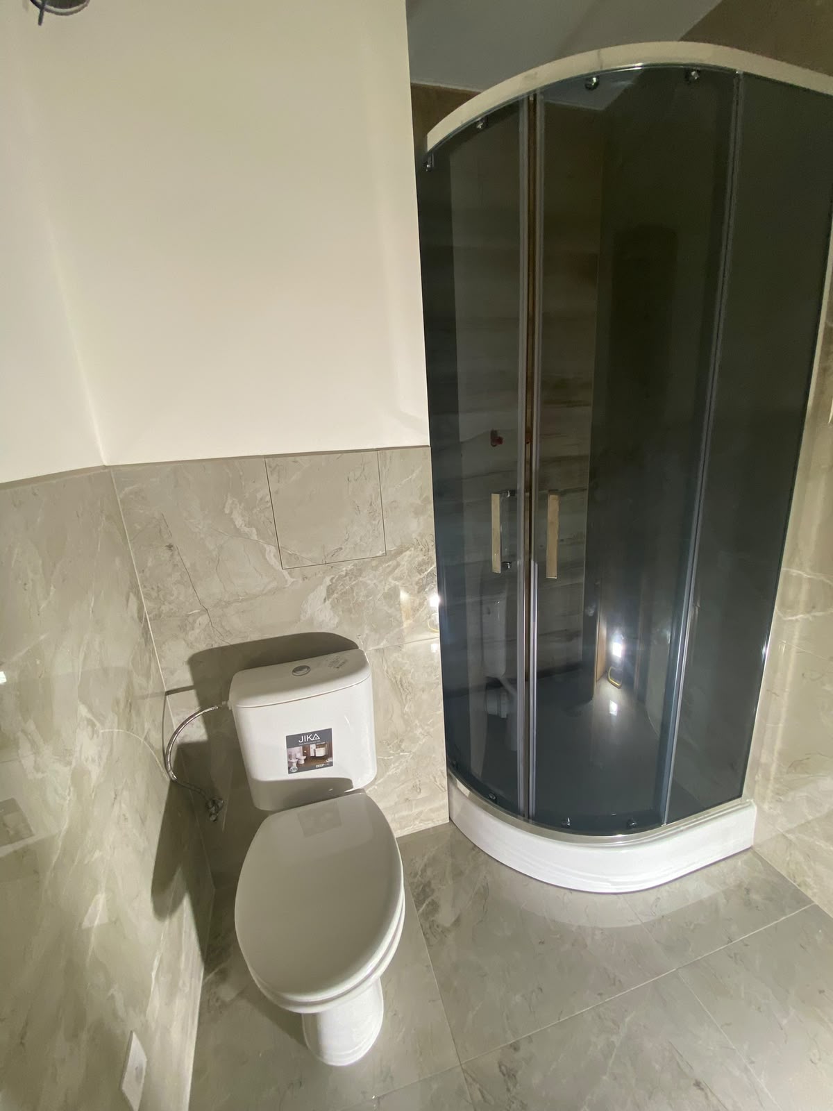 Koupelna se sprchovým koutem, WC a světlými obklady po rekonstrukci bytu 32 m²
